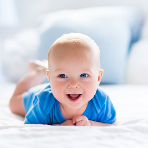 happy-infant-smiling-and-laughing-laying-on-bed